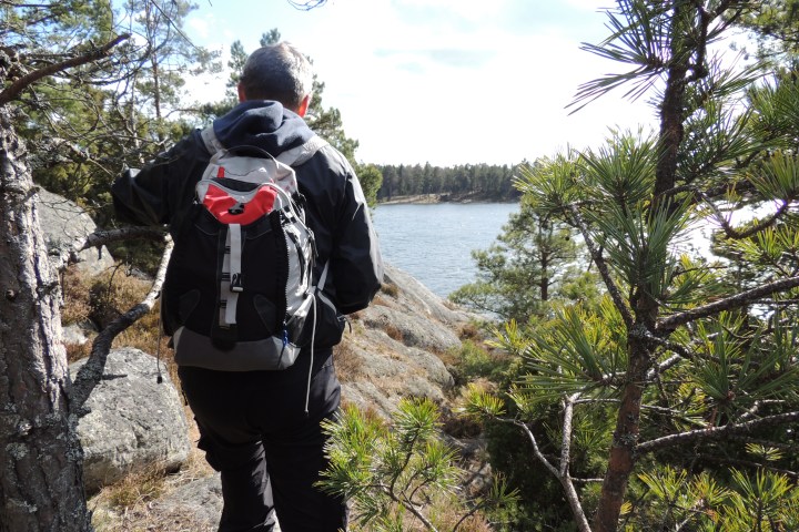 man overlooking lake on self guided hike in stockholm