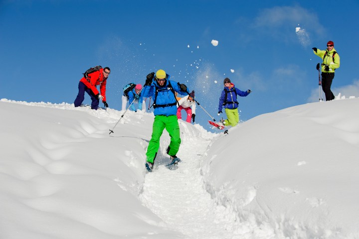 a group of people riding skis down a snow covered slope